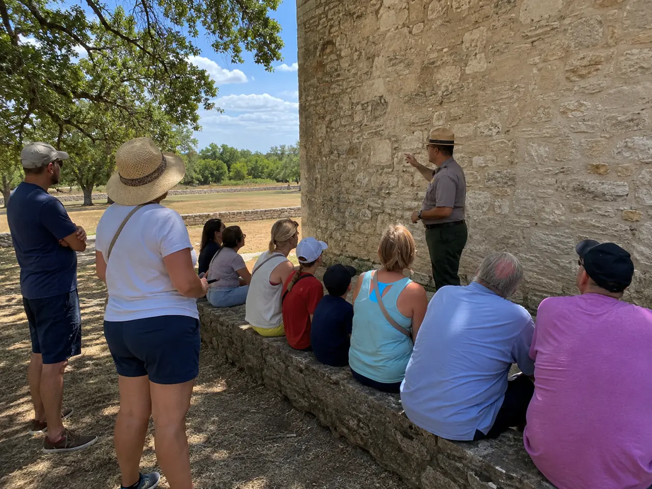 A ranger in a flat-brim hat talking to a small group in the open air